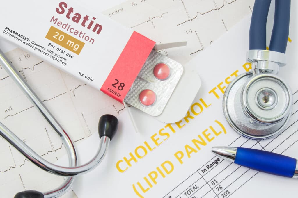 Statin medication on top of paper and sitting next to stethoscope.