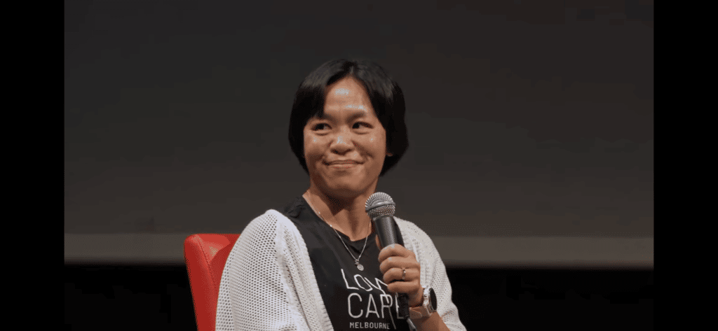 Dr. Avi Charlton, a Keto GP holding a microphone while sitting and smiling.