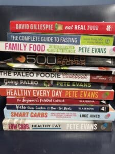 Weight loss and nutrition books stacked on top of eachother.