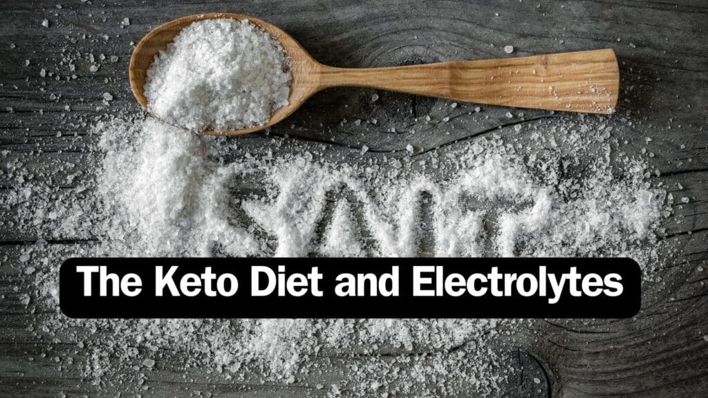 Wooden spoon filled up with salt on table with a label saying The Keto Diet and Electrolytes next to the spoon.