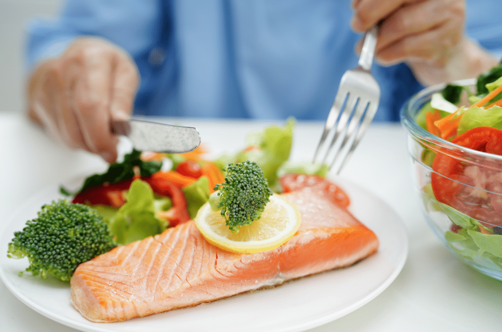 Man eating a healthy dinner with salmon for their weight loss journey.