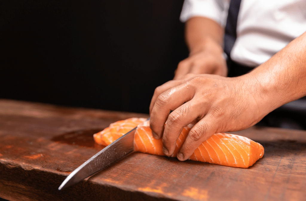 Man cutting raw salmon.