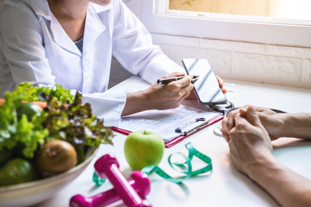 Weight loss doctor showing her patient a workout routine on her phone.