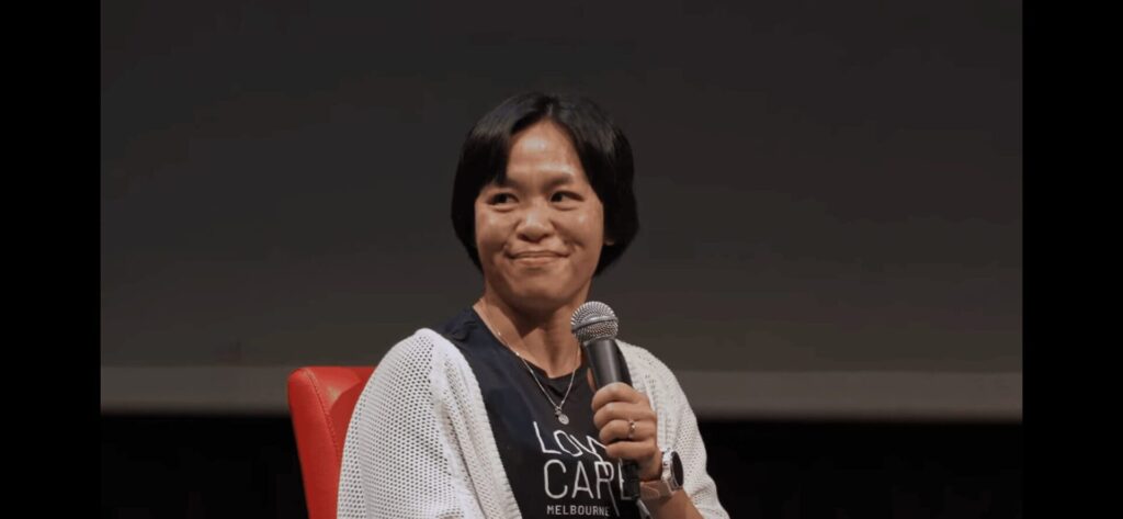 Dr. Avi Charlton, a weight loss specialist holding a microphone while sitting and smiling.