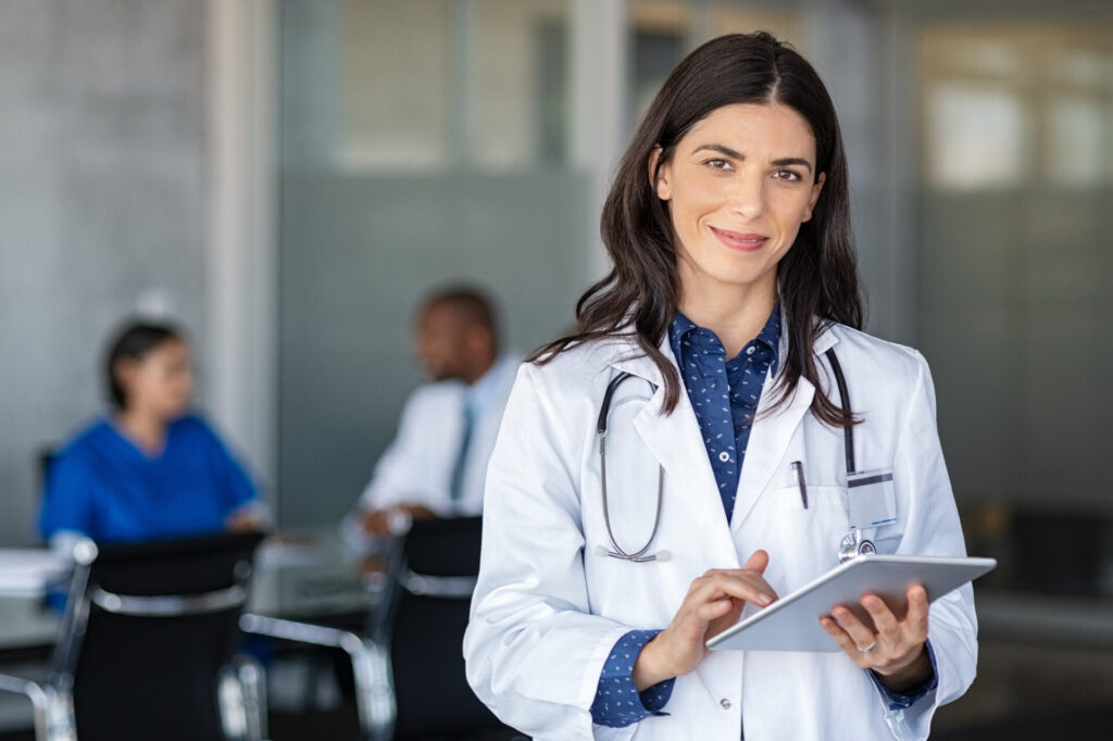 Medical weight loss doctor smiling while holding a tablet.